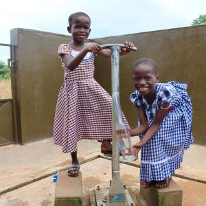 two girls pumping water